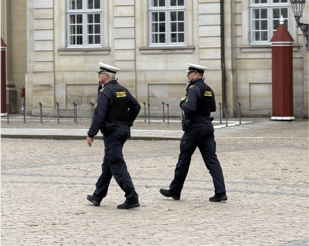To politibetjente patruljerer foran historisk bygning i København